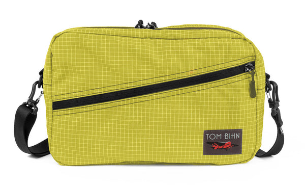 A Packing Cube Shoulder Bag in Wasabi (green with white grid) 200 Halcyon with a shoulder strap.